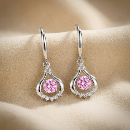 Pink 925 sterling silver teardrop dancing crystal earrings close up on soft fabric