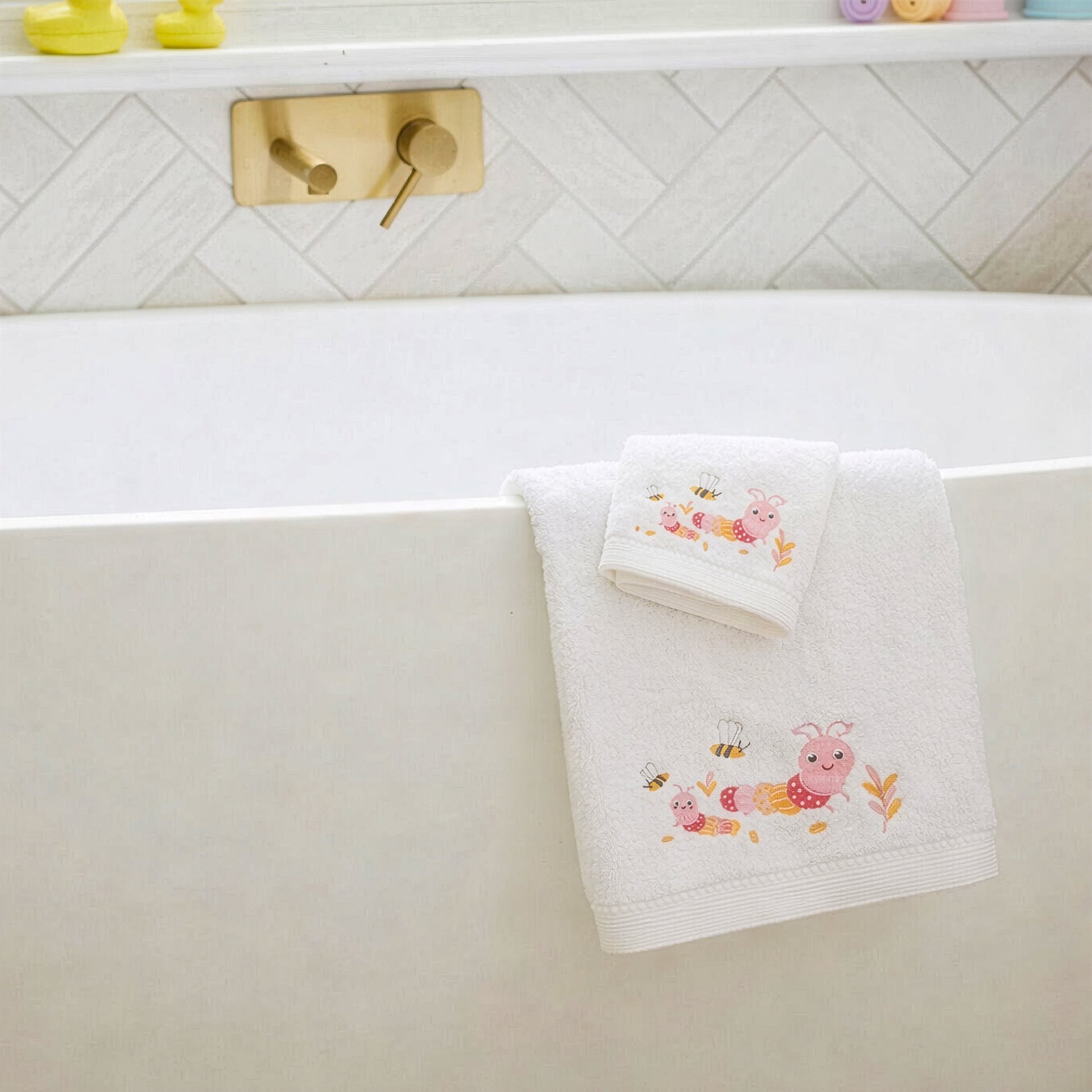 Pink baby towel and matching face washer hanging in bathroom