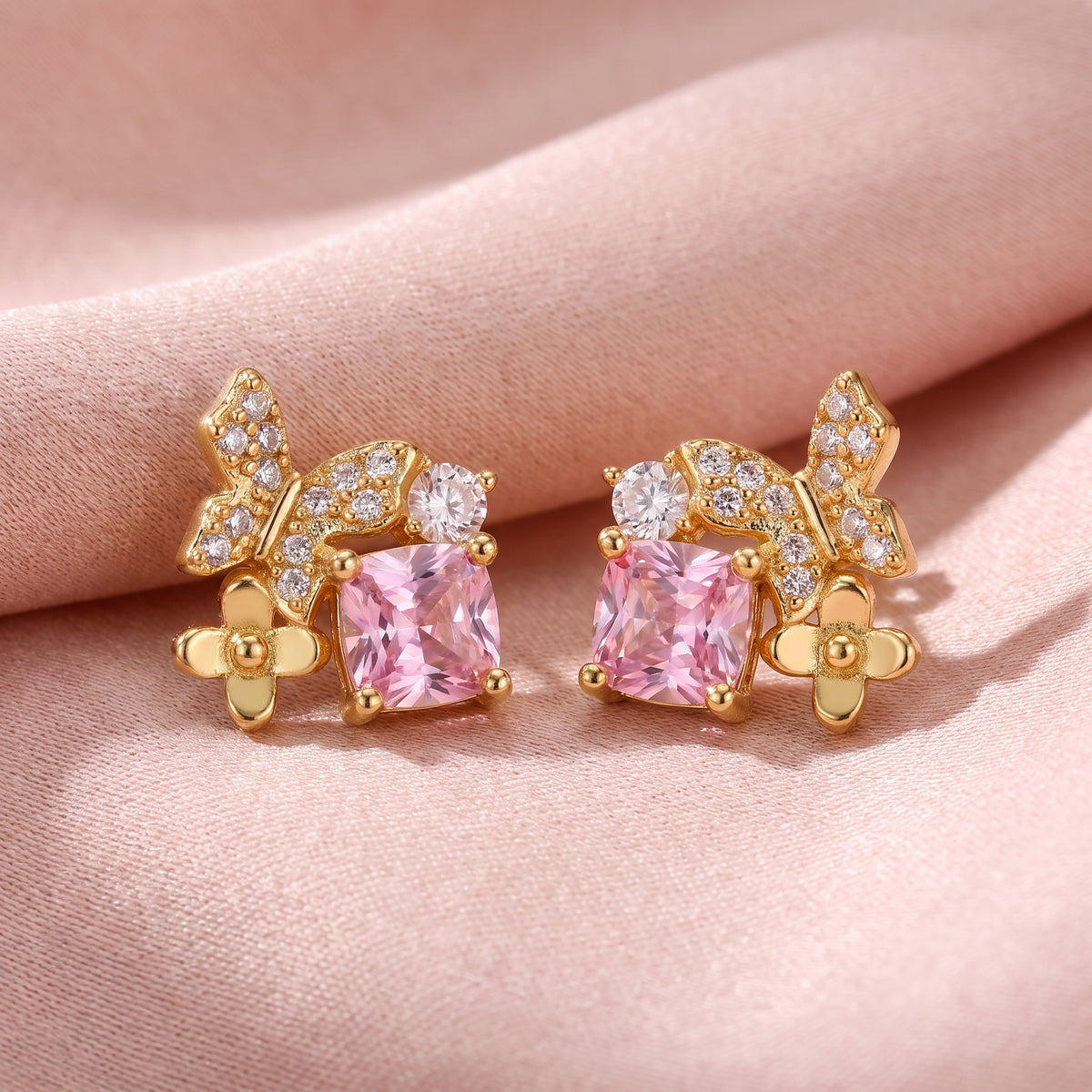 Close-up of pink Gold Butterfly Garden stud earrings with sparkling stones