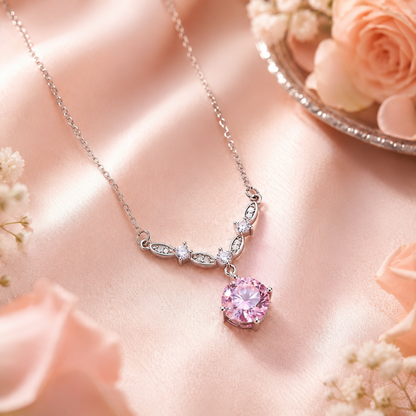 A delicate 925 Sterling Silver Pink Cubic Zirconia Floral Vine Necklace adorned with small clear stones and a prominent round pink gemstone, displayed on soft pink satin fabric with floral accents.