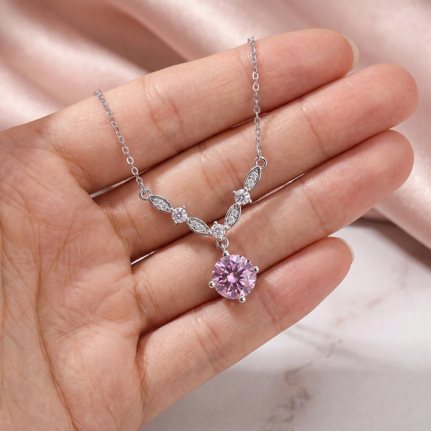 925 sterling silver floral vine necklace shown on hand with pink cubic zirconia pendant