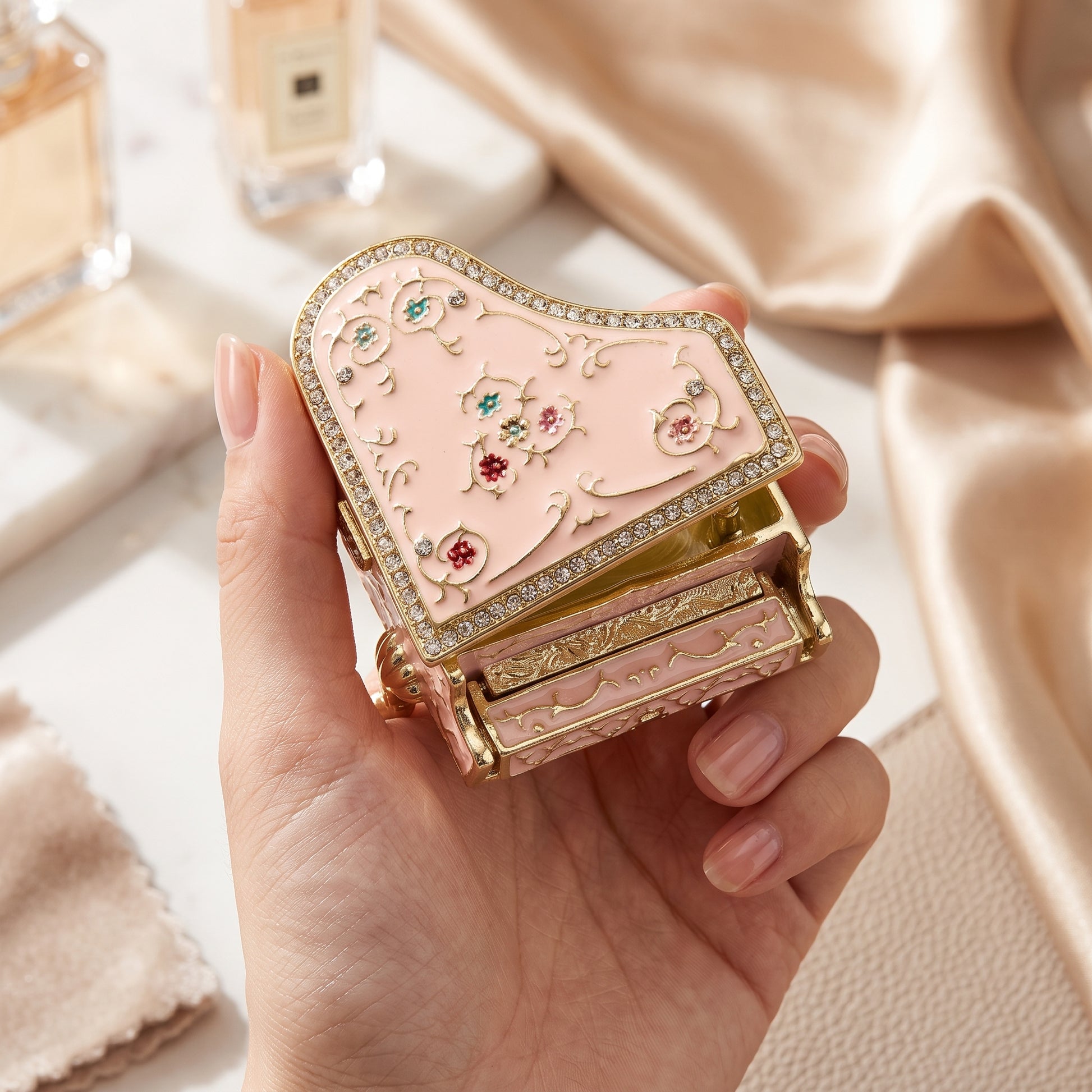 Pink floral grand piano jewellery box held in one hand