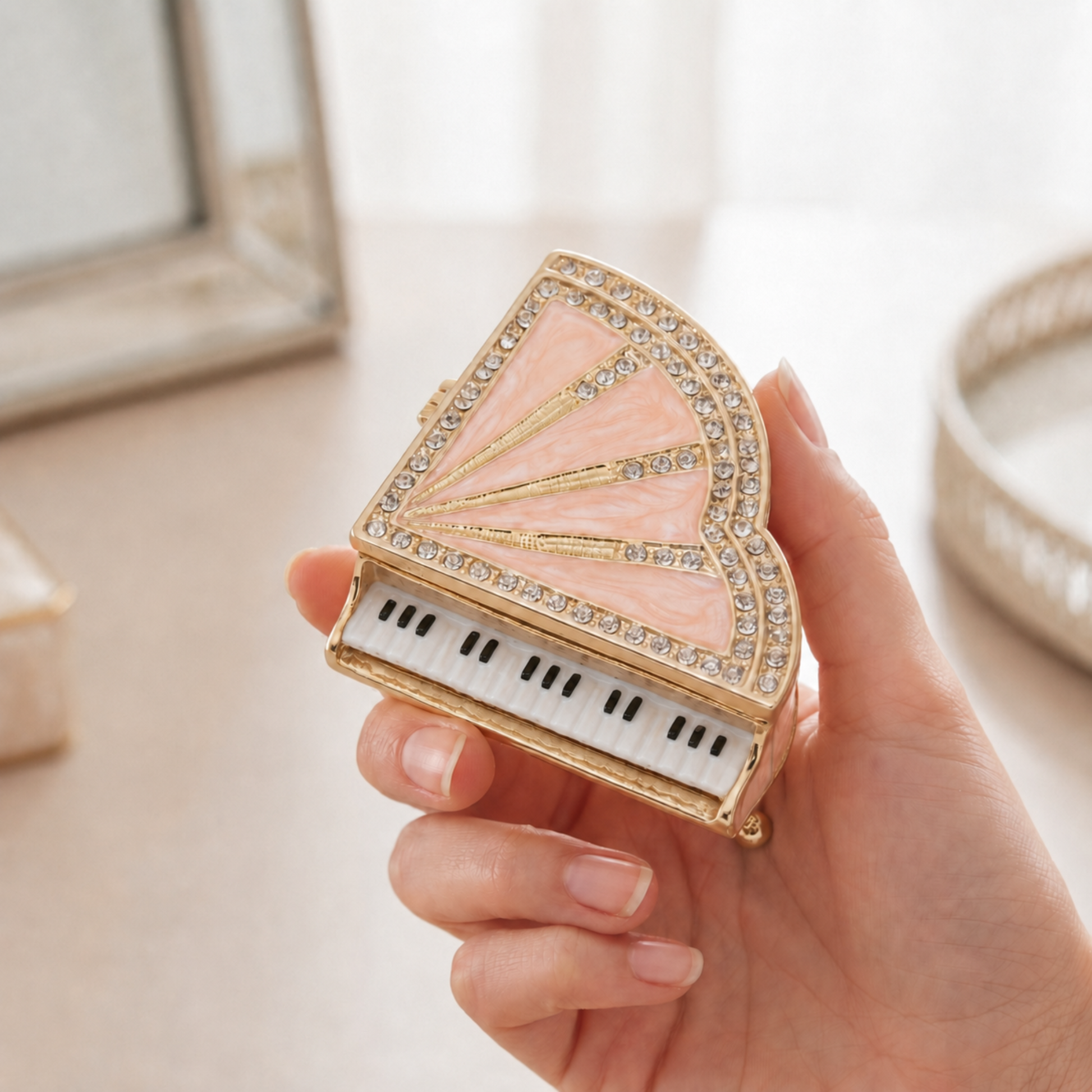 Pink miniature grand piano jewellery box held in a woman’s hand