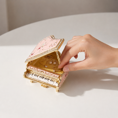 Woman placing jewellery inside a pink grand piano jewellery box
