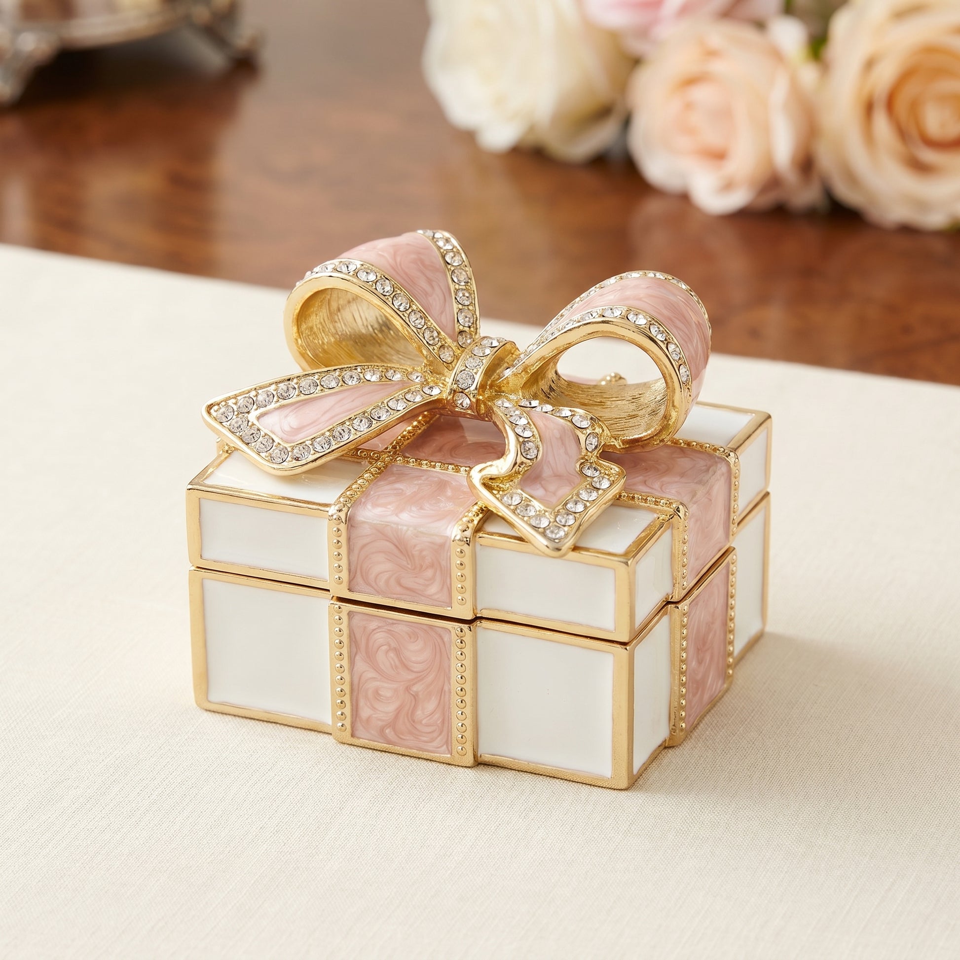 Pink vintage bow gift box enamel crystal jewellery box with gold trim and sparkling bow detail, ideal as a gift for her, on table.