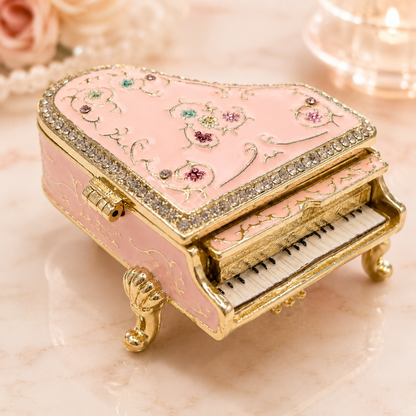 Pink vintage floral grand piano jewellery box, set on a light marble surface with soft decorative background elements.