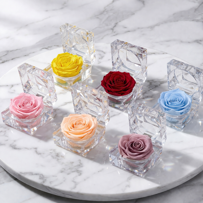 Colorful preserved roses in crystal holders on a marble surface with a soft background