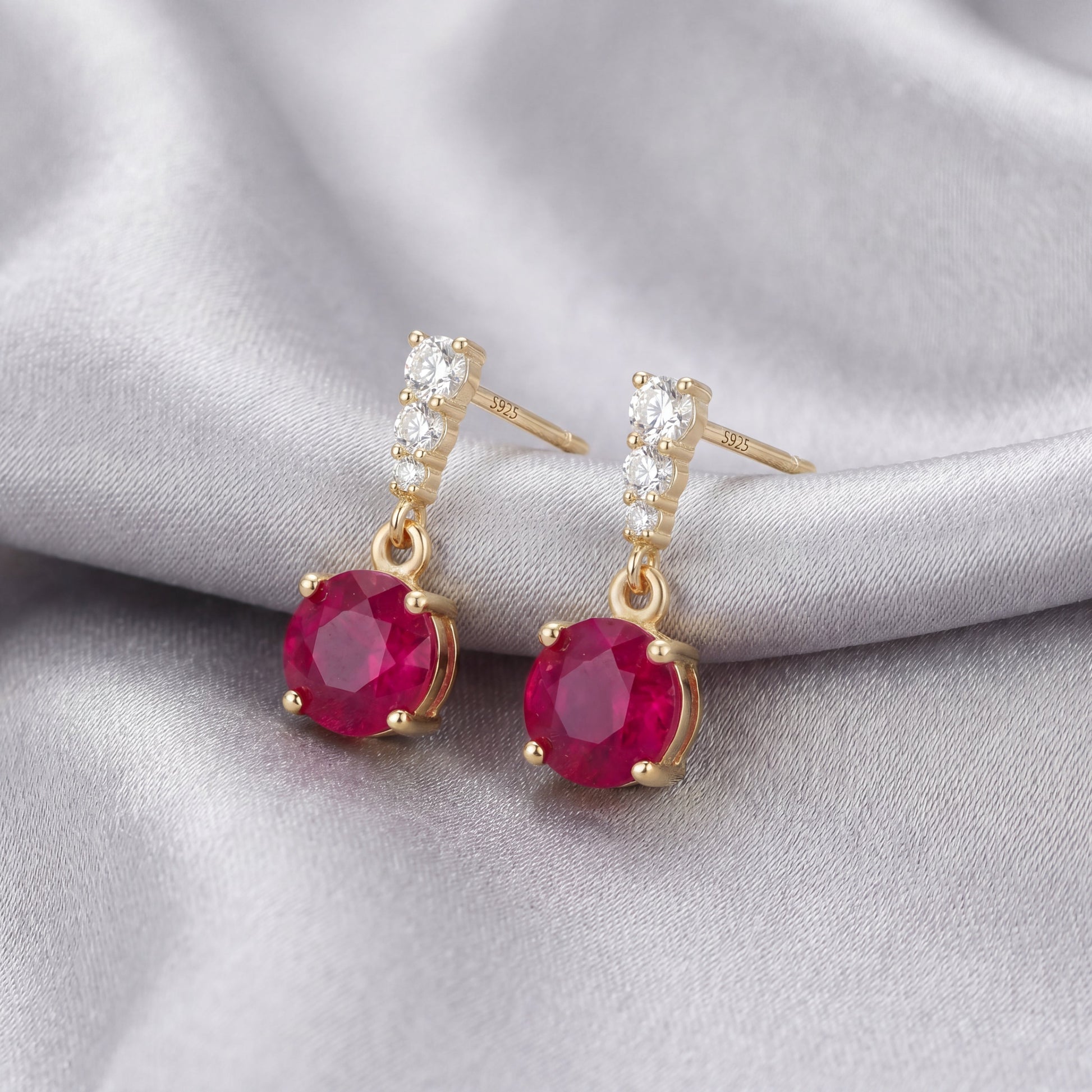 Angled view of 18K gold plated 925 sterling silver red cubic zirconia drop stud earrings