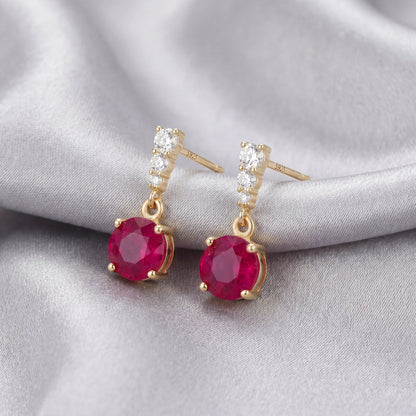 Angled view of 18K gold plated 925 sterling silver red cubic zirconia drop stud earrings