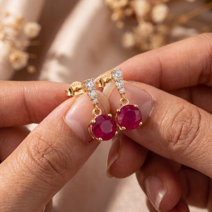 18K gold plated 925 sterling silver red cubic zirconia drop stud earrings held in hands