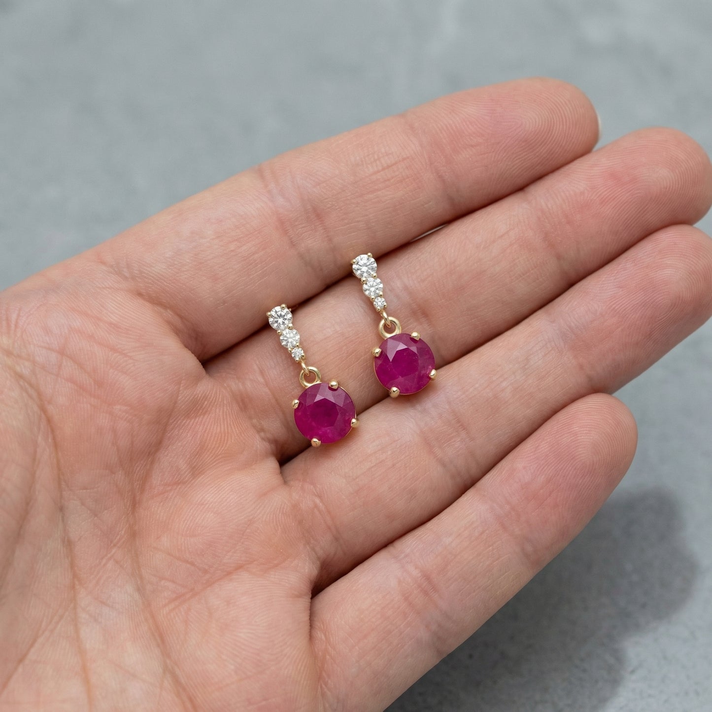 18K gold plated 925 sterling silver red cubic zirconia drop stud earrings shown in hand for size