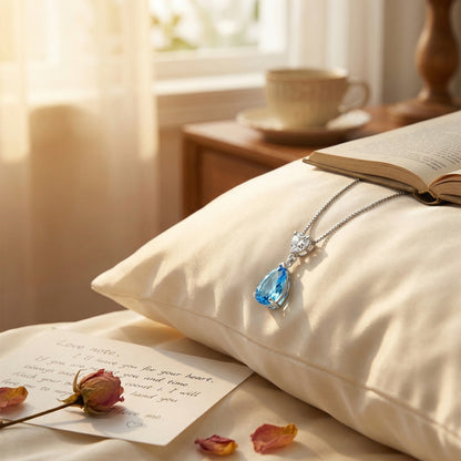 Romantic blue ocean heart necklace styled on pillow with love note, meaningful gift for her in Australia