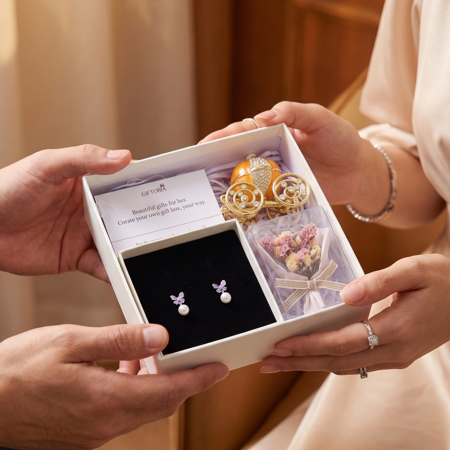 Woman receiving a romantic gift set with butterfly earrings, dried flowers and a carriage jewellery box