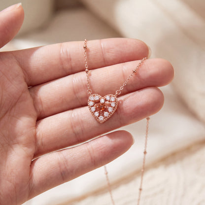 Rose gold red sparkle heart pendant necklace held in hand to show the pendant size