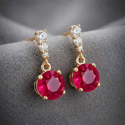 Close-up of ruby red cubic zirconia drop earrings with gold tone settings