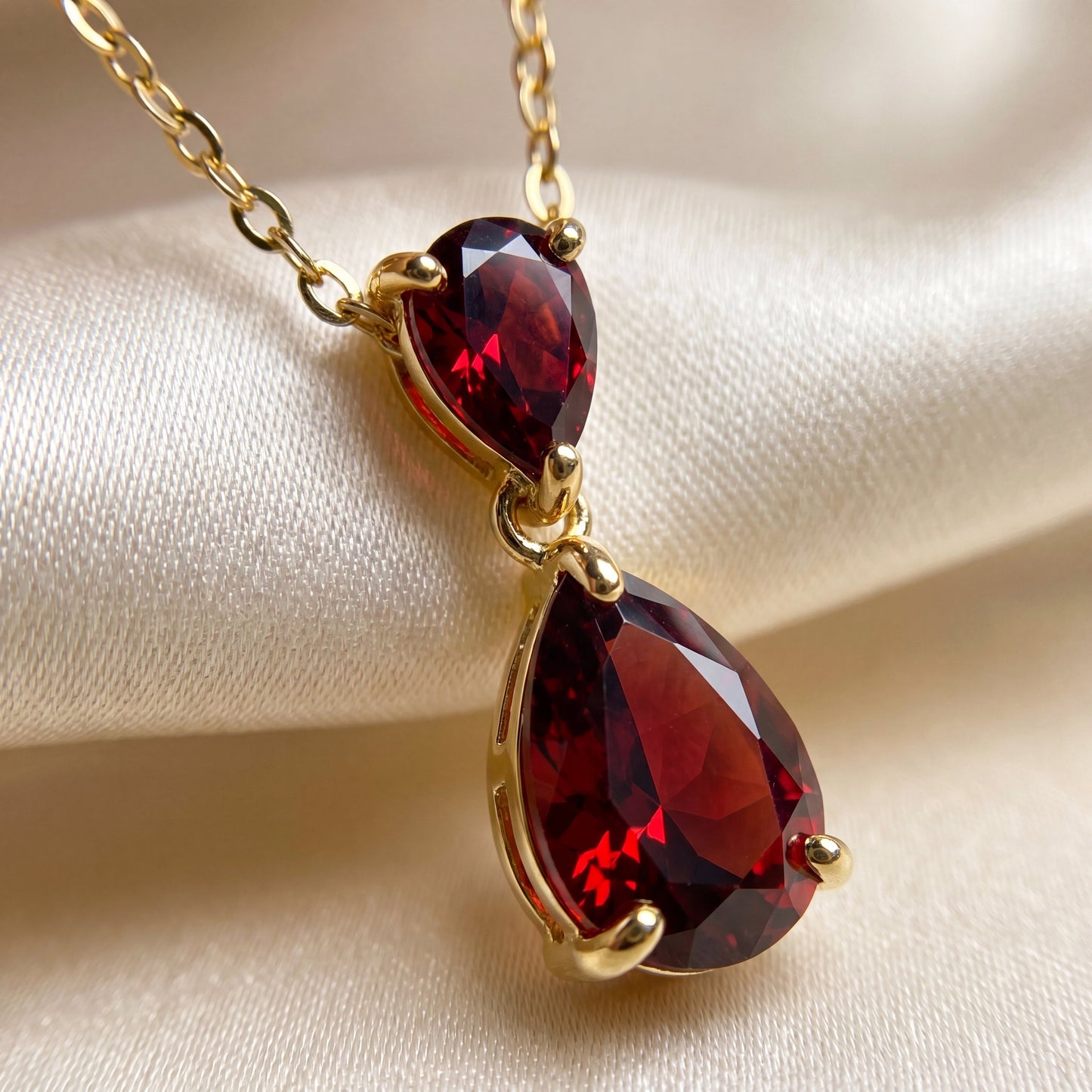 Close-up of the ruby red teardrop pendant and 18K gold plated setting