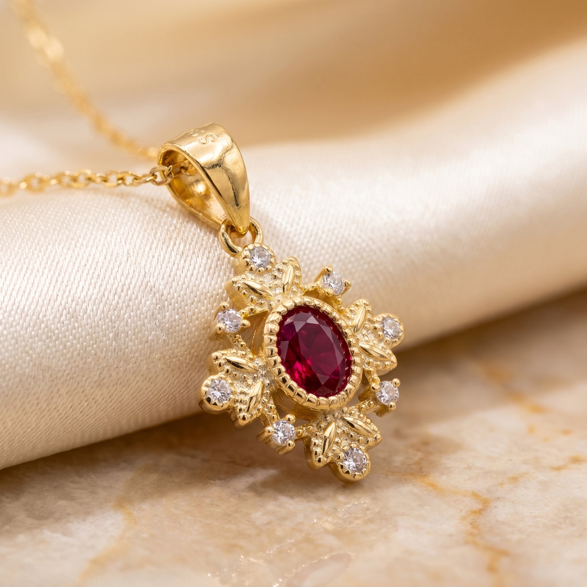 Close-up of a gold 925 sterling silver ruby red vintage pendant with sparkling crystal details