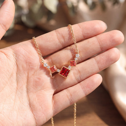 Gold Scarlet Vintage red cubic zirconia necklace displayed by hand in natural light