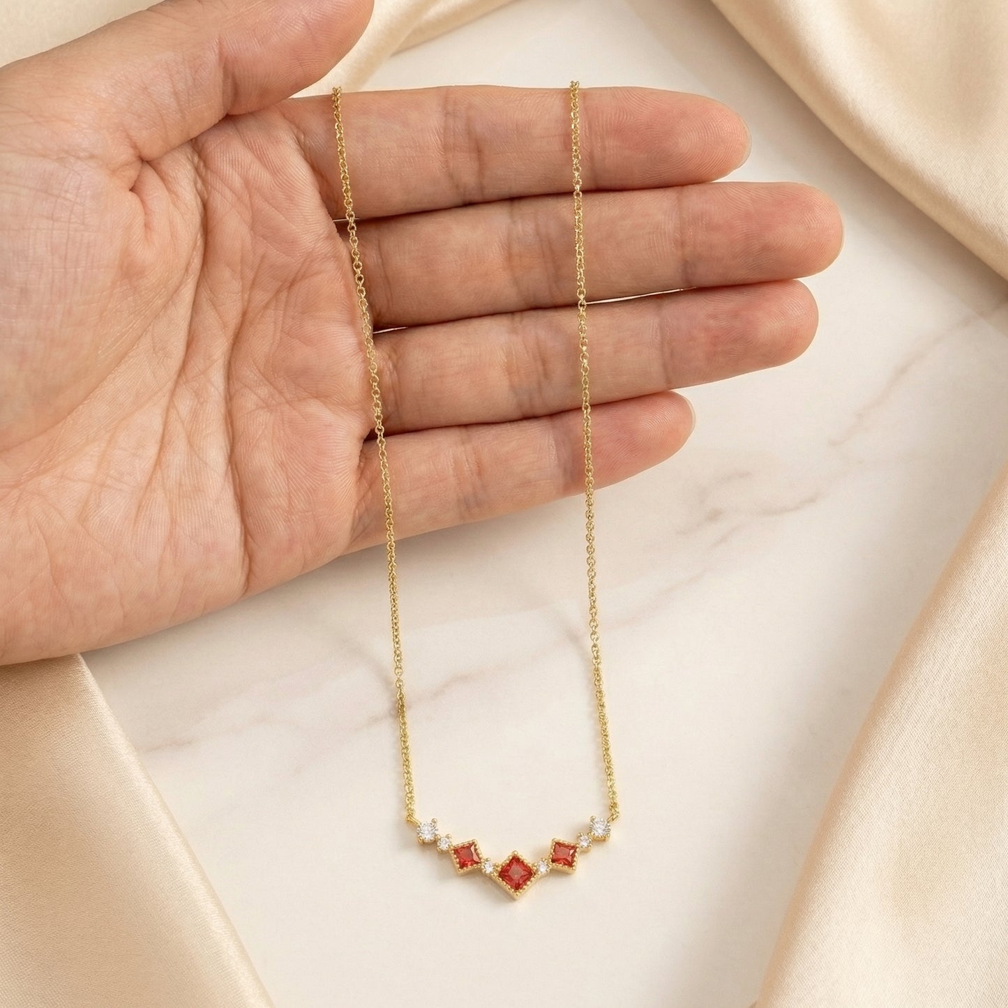 Scarlet vintage red cubic zirconia necklace shown in hand to display chain length