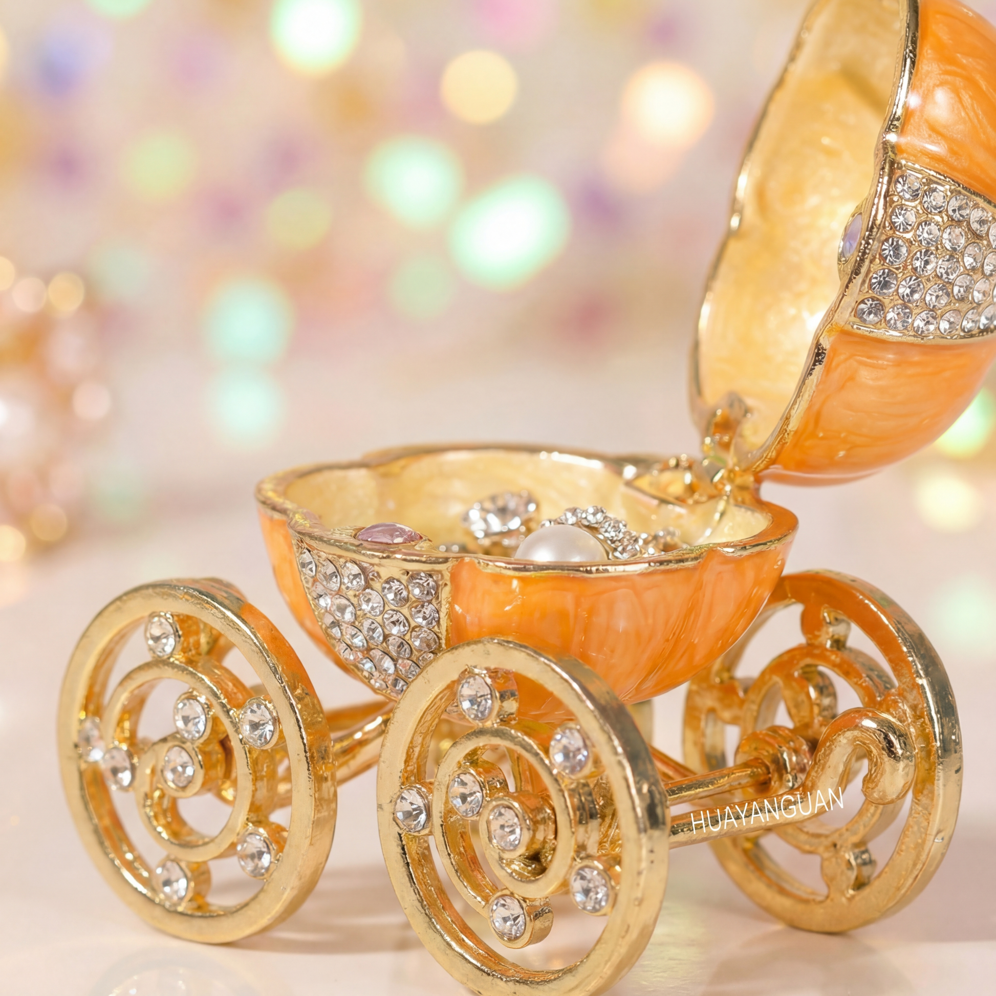 Sparkling orange pumpkin carriage jewellery box opened to show jewellery storage space and gold carriage wheel design.