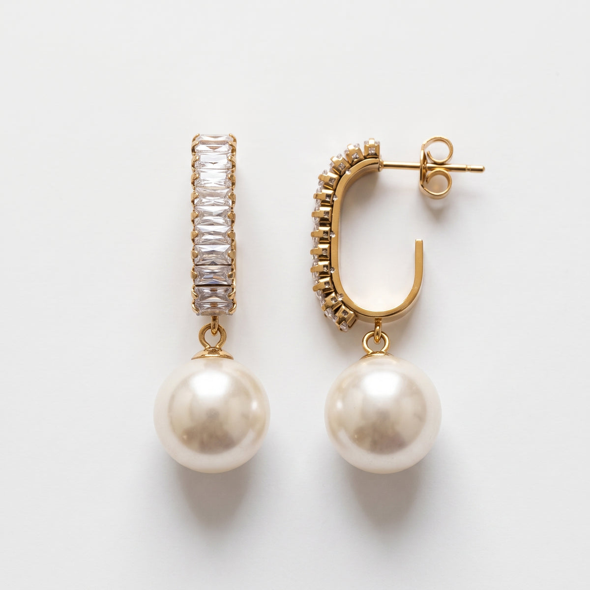 Angled close-up of sparkling baguette crystal hoops and luminous pearl drops