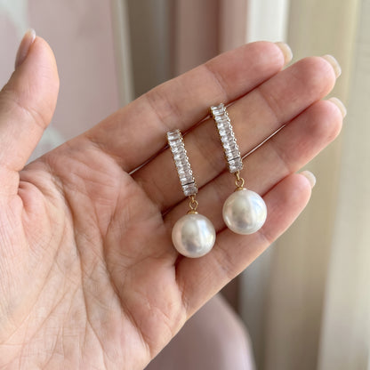 Statement Sparkling Baguette Pearl Drop Earrings held in hand to show their size and pearl drops