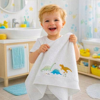 Smiling toddler holding dinosaur baby bath towel