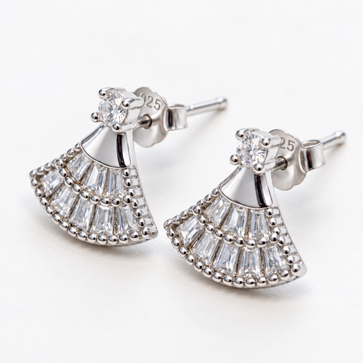 Angled view of the silver fan-shaped earrings, showing the studs and stone-set design.