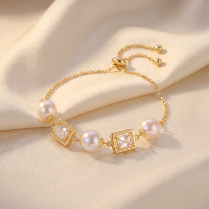 Vintage pearl square cubic zirconia gold bracelet angled view on soft neutral fabric