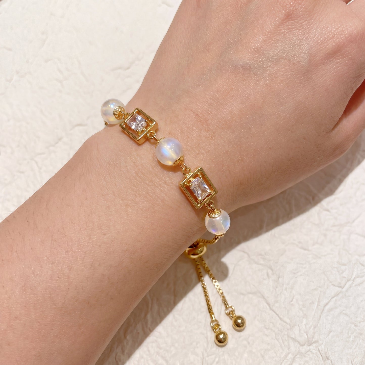 Vintage pearl square cubic zirconia gold bracelet worn on wrist with elegant adjustable chain