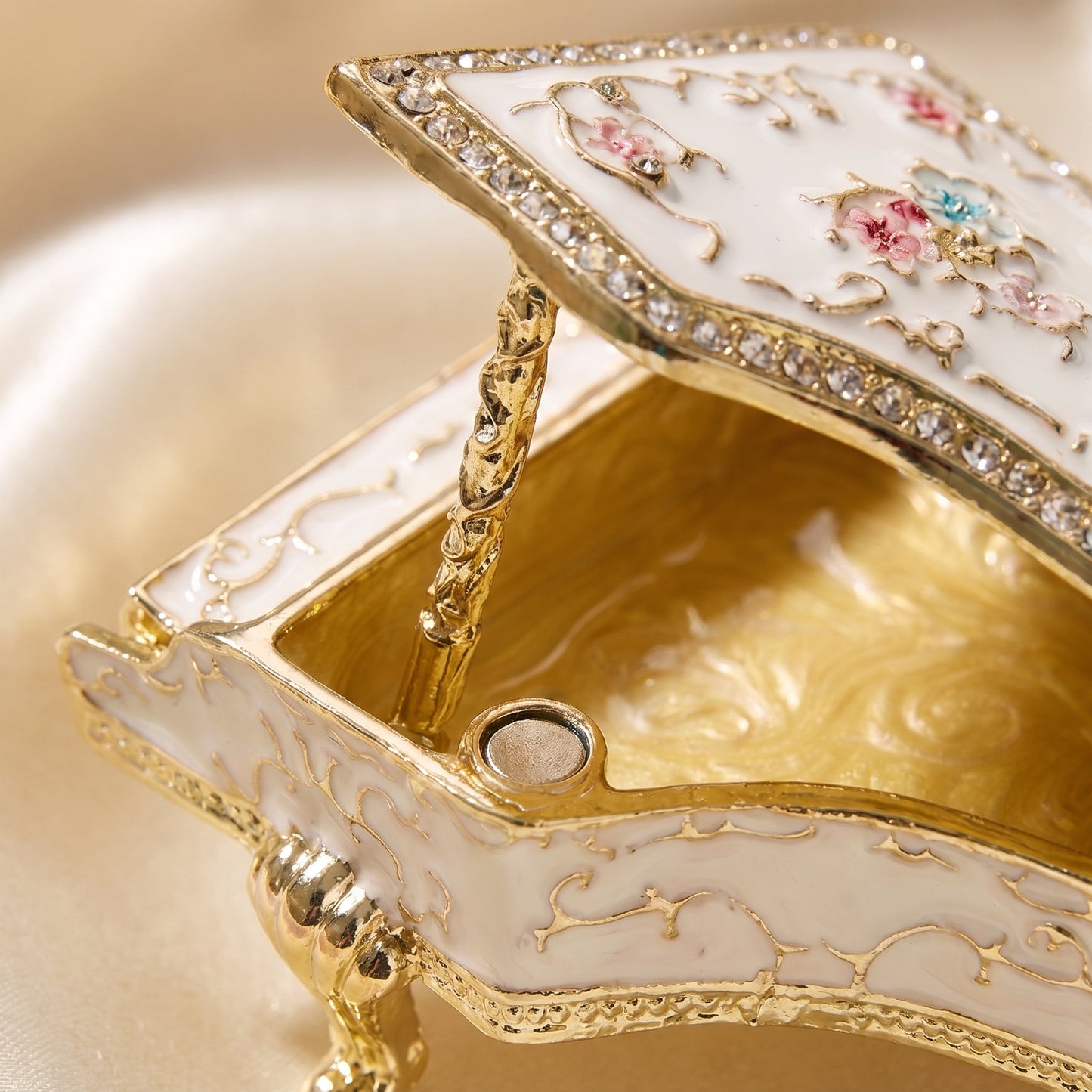 Open white grand piano jewellery box showing gold storage interior