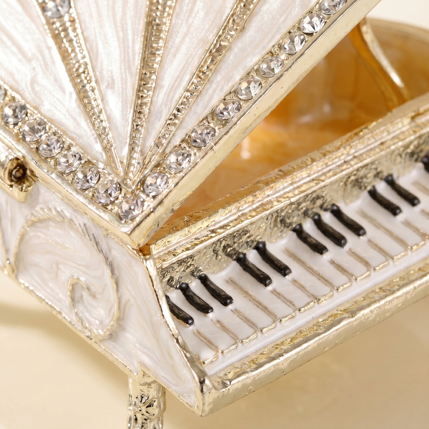 Close up of white piano jewellery box with crystal details and piano keyboard design.