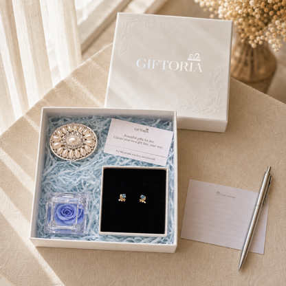 Open Giftoria gift set beside its lid and gift card with butterfly earrings, blue rose and pearl jewellery box